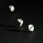 3 white dice on black surface